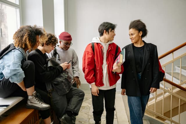 Grupo de jóvenes felices caminando hacia un lugar con sol